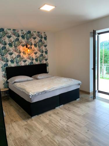 una camera da letto con un letto grande con una parete di Apartmány Županovice a Dobříš