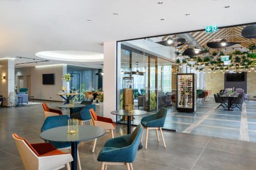a restaurant with tables and chairs in a room at Mercure Tokaj Center in Tokaj