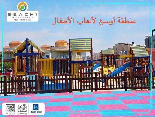 einen Spielplatz mit bunter Spielausrüstung vor einem Gebäude in der Unterkunft شاليه راقي بمارسيليا بيتش 1 الساحل in Dawwār Muḩammad Abū Shunaynah