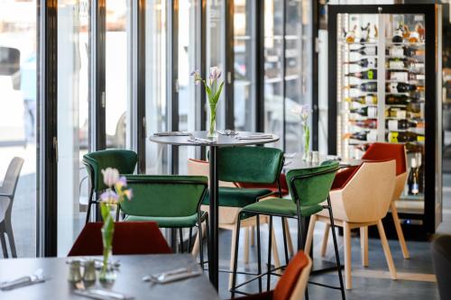 a restaurant with tables and chairs with flowers on them at Mercure Tokaj Center in Tokaj