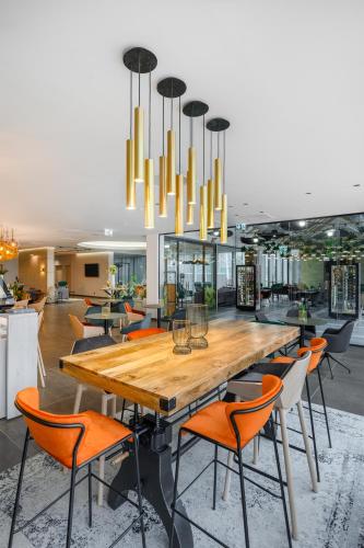 a dining room with a large wooden table and chairs at Mercure Tokaj Center in Tokaj