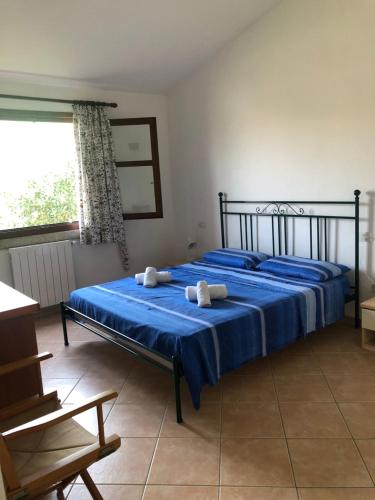 a bedroom with a blue bed with towels on it at Residence Uliveto app 33 Birgalavo' in Agrustos