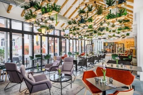 a restaurant with tables and chairs and windows at Mercure Tokaj Center in Tokaj