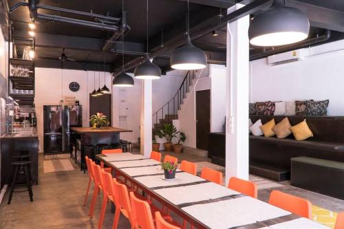 a dining room with a long table and orange chairs at Beautiful Super Modern Gigantic Designer Home in Bangkok