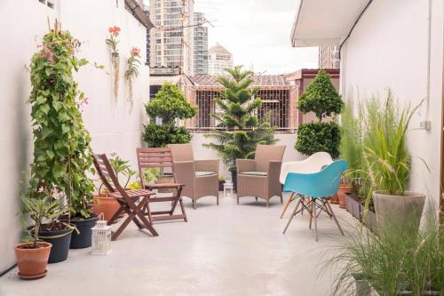 an outdoor patio with chairs and plants at Beautiful Super Modern Gigantic Designer Home in Bangkok