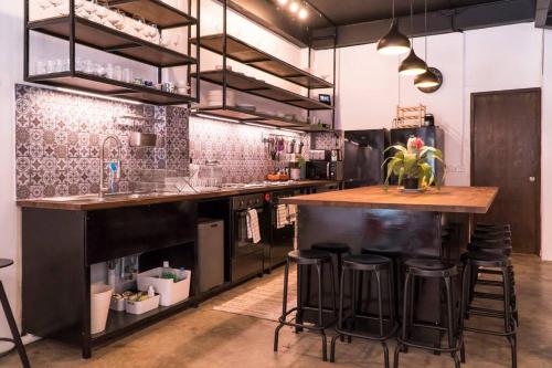 a kitchen with a counter and stools in it at Beautiful Super Modern Gigantic Designer Home in Bangkok
