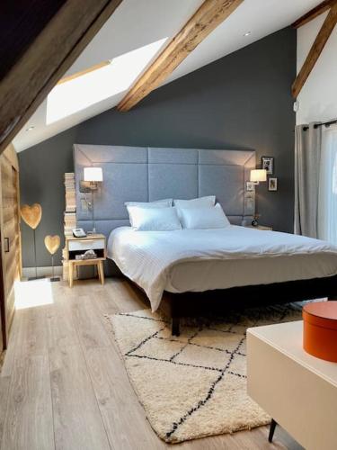une chambre avec un grand lit avec un mur bleu dans l'établissement Appartement Mocca au coeur de Chamonix Mont-Blanc, à Chamonix-Mont-Blanc