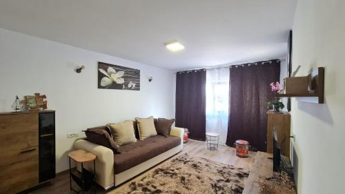 Una sala de estar con un sofá y un televisor. en Iulia Sulina Deluxe, en Sulina