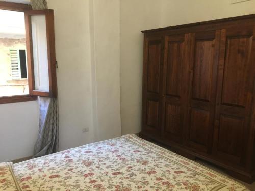 菲利內瓦爾達諾的住宿－Terrazza il canto al romano，一间卧室配有一张床和一扇木门