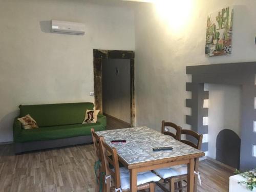菲利內瓦爾達諾的住宿－Terrazza il canto al romano，客厅配有桌子和绿色沙发
