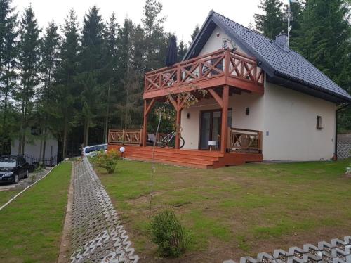 ein Haus mit einer großen Terrasse an der Seite in der Unterkunft Eden nad Lubie Linowno 