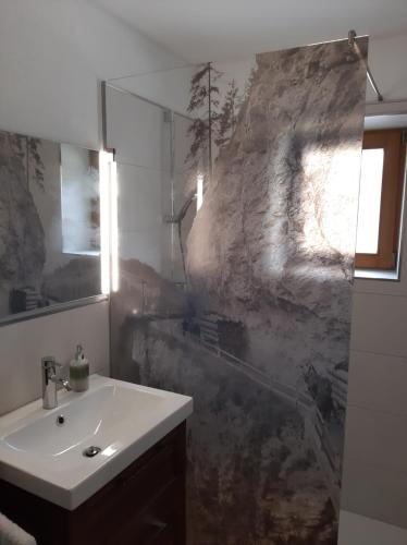 a bathroom with a sink and a stone wall at Ferienwohnung Valentin in Grossarl