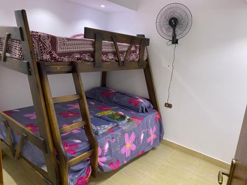 een kamer met 2 stapelbedden en een ventilator bij Palmera Resort Ain Sokna - Building No# 32 Flat No# 4 in Suez