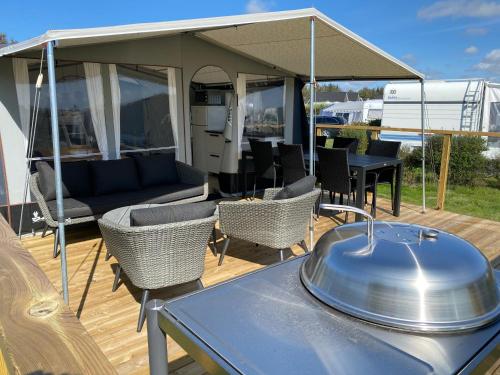 a patio with a table and chairs and a tent at Løkken Klit Camping & Cottage Village in Løkken
