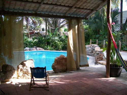 a chair sitting in front of a swimming pool at Posada El Jardin in Ticul