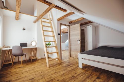 1 dormitorio con escalera, cama y escritorio en Drive Caffe Apartments, en Trzin