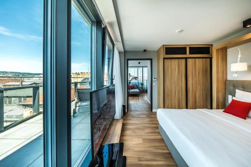 a hotel room with a bed and a balcony at Up Hotel Budapest in Budapest