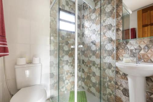 a bathroom with a shower and a toilet and a sink at Casa Litoral Sul de São Paulo, Peruibe in Itariri