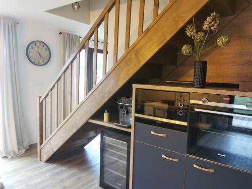 a kitchen with a staircase with a clock on the wall at Naše Borovka in Borová Lada