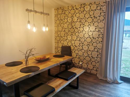 a dining room table and chairs with a wall at Naše Borovka in Borová Lada
