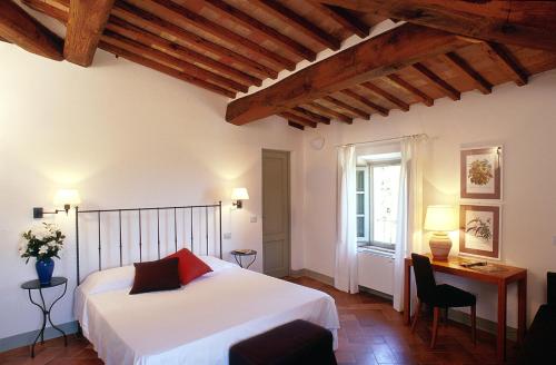 een slaapkamer met een bed, een bureau en een raam bij Villa Ducci in San Gimignano