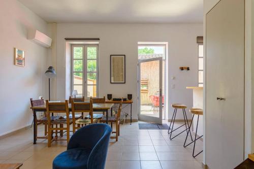 eine Küche und ein Esszimmer mit Tisch und Stühlen in der Unterkunft Maison de village façon Loft, avec cour et airco, dans le centre historique in LʼIsle-sur-la-Sorgue