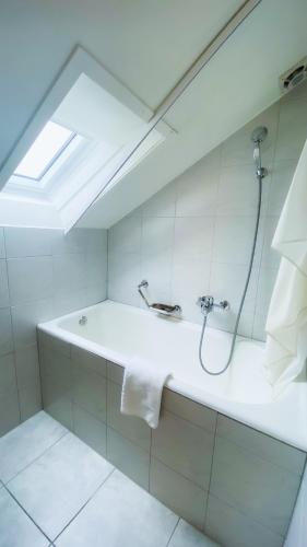 a bathroom with a bath tub with a shower at Hotel Spatz in Luzern