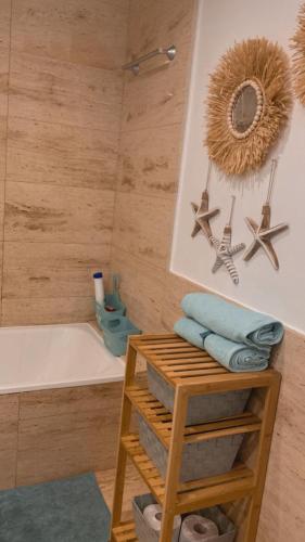 a bathroom with a bath tub and a table with towels at sabanell park in Blanes