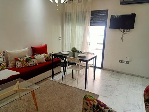 een woonkamer met een bank en een tafel bij Studio Des Nations Miramar Mohammedia in Mohammedia
