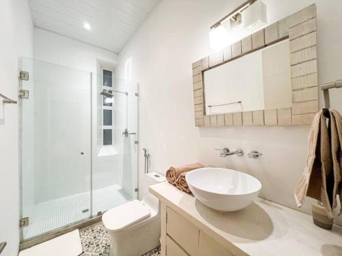 a white bathroom with a sink and a shower at Apartamento en el Corazón de Casco Viejo Panamá 13 in Panama City