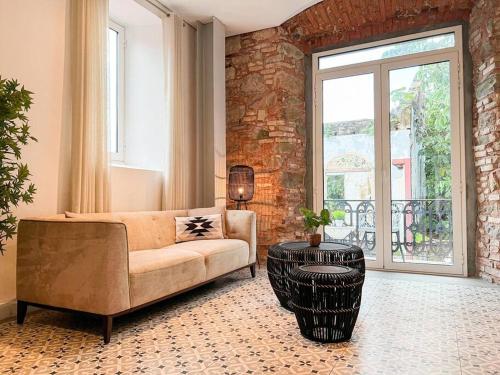 ein Wohnzimmer mit einer Couch und einer Ziegelwand in der Unterkunft Apartamento en el Corazón de Casco Viejo Panamá 13 in Panama-Stadt