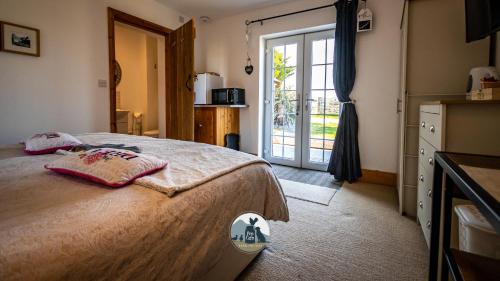 a bedroom with a bed and a sliding glass door at Conwy Pen Cefn Farm Holiday in Abergele