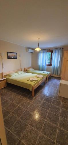a bedroom with a large bed and blue curtains at Villas Chinara in Kranevo