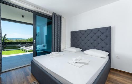 a bedroom with a large bed and a large window at Villa Twins in Crikvenica