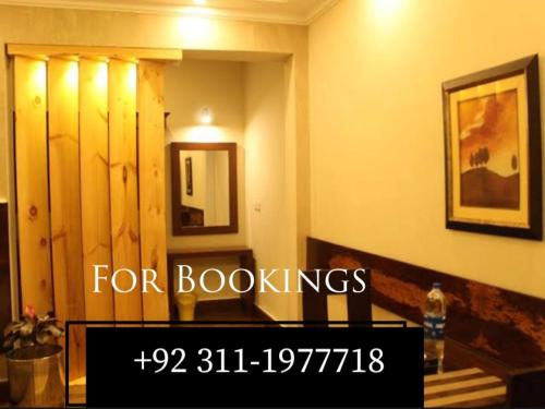 a sign that reads for bookings in a room at The Corner Inn Guest House in Karachi