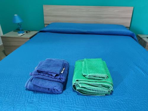 a bed with blue and green towels on it at Sa Dommu 'e su coro in Triei