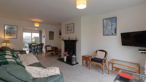 巴里卡斯爾的住宿－Strand Cottages Ballycastle Seafront，带沙发和壁炉的客厅