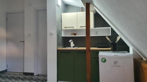 a small kitchen with green cabinets and a sink at TOP 3 Apartments in Strumica