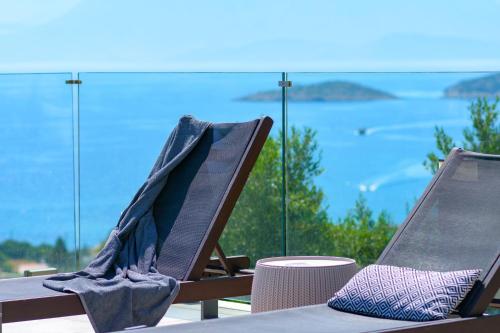 two chairs sitting on a table with a view of the ocean at Villa Sophia in Agios Nikolaos