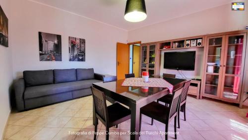een woonkamer met een tafel en een bank bij Scala dei Turchi Apartment in Realmonte