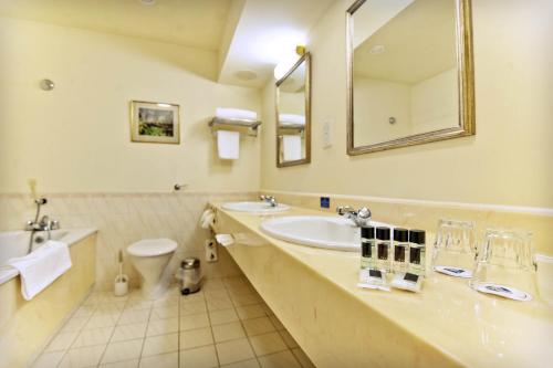 a bathroom with a sink and a toilet and a mirror at Penmere Manor Hotel in Falmouth