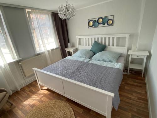 een slaapkamer met een groot wit bed met blauwe kussens bij Ferienwohnung Matilde in Bad Grund
