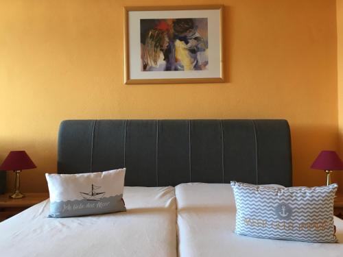 a bed with a black headboard and two pillows on it at Super-Ostseeferien in Graal-Müritz
