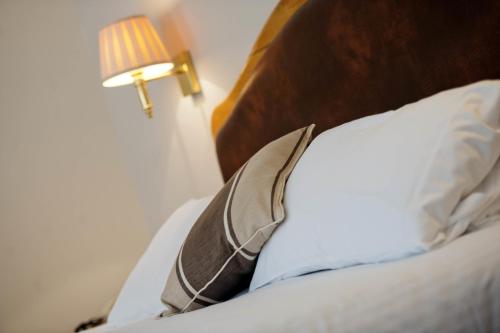 a close up of a bed with a pillow and a lamp at Penmere Manor Hotel in Falmouth