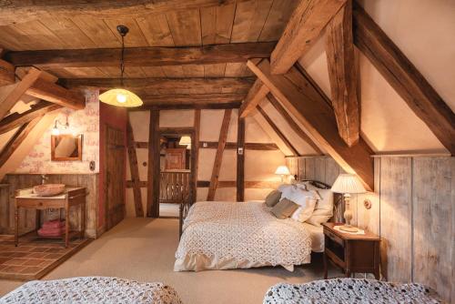 a bedroom with a bed in a room with wooden ceilings at Au Fil du Temps in Imbsheim