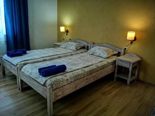 two beds in a bedroom with blue pillows on them at Paunovi Guest House in Primorsko