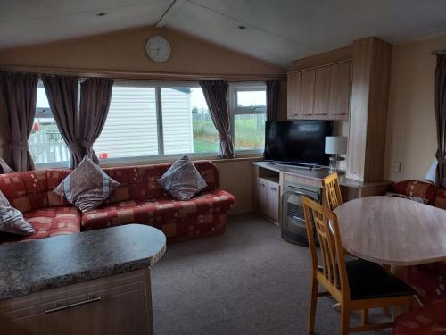 a living room with a couch and a table at 6 Berth The Chase Ingoldmells (The Rio) in Ingoldmells