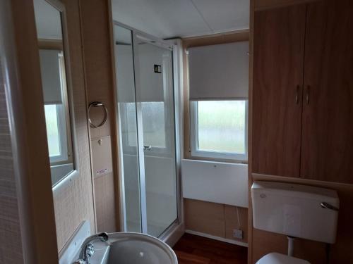 a bathroom with a sink and a glass shower at 6 Berth The Chase Ingoldmells (The Rio) in Ingoldmells