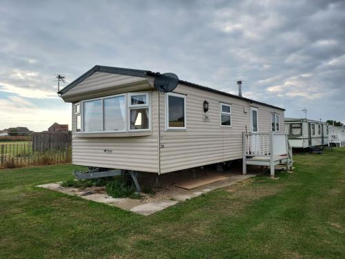 a white tiny house sitting in a yard at 6 Berth The Chase Ingoldmells (The Rio) in Ingoldmells
