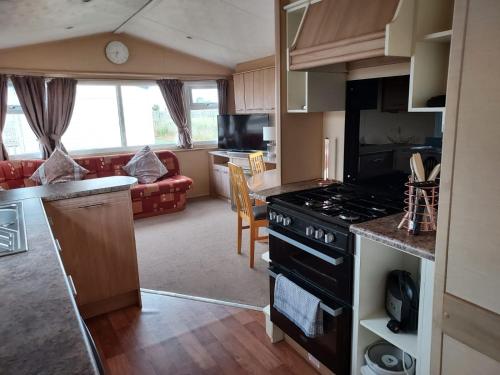 a kitchen and living room with a stove top oven at 6 Berth The Chase Ingoldmells (The Rio) in Ingoldmells